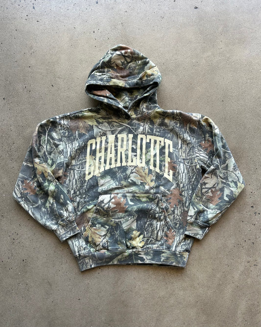 Camouflage hoodie with 'Charlotte' text on a gray surface