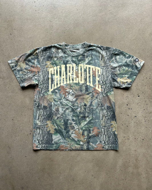 Camouflage t-shirt with 'Charlotte' text on a concrete floor